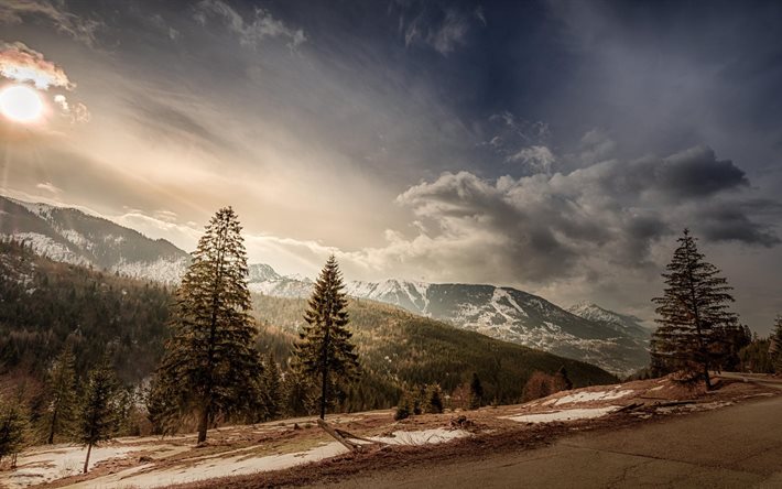 snow, mountains, spruce, the sun, the sky, road, clouds, forest