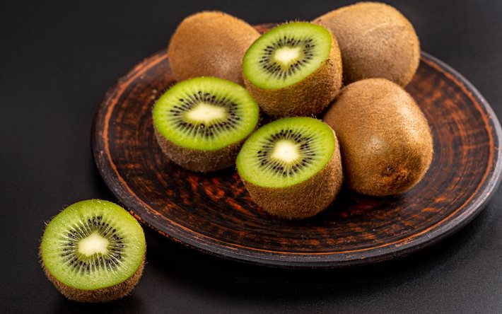 kiwi på en tallrik, frukt, wiki, källa till vitamin c, kiwi bakgrund, friska frukter, kinesisk krusbär, kiwifrukt
