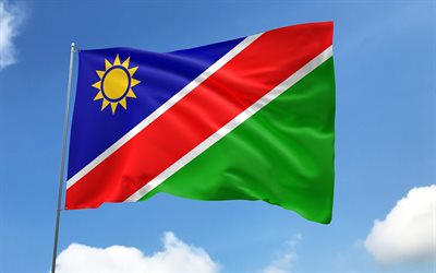 namibia flagge am fahnenmast, 4k, afrikanische länder, blauer himmel, flagge namibias, gewellte satinfahnen, namibische flagge, namibische nationalsymbole, fahnenmast mit fahnen, tag namibias, afrika, namibia flagge, namibia