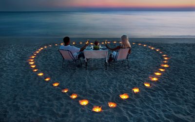 los amantes de la orilla, la arena, el mar, el par, el océano, el agua, la mujer, la mesa, las copas, champán, el hombre, las velas, el corazón de la noche