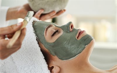 spa-mask för ansiktet, spa-behandlingar, kosmetiska behandlingar, spasalong, applicering av masker i ansiktet, lermask för ansiktet, rengörande ansiktsmask, kvinna i spasalongen, skönhetsbehandlingar